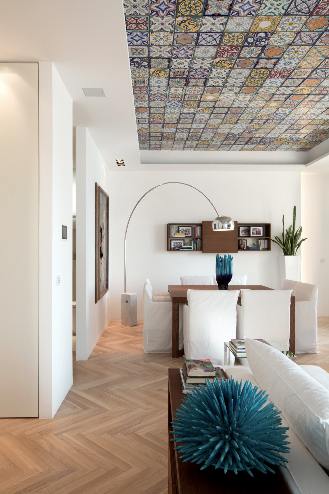 Источник вдохновения для домашнего уюта: огромная гостиная-столовая в средиземноморском стиле с белыми стенами, светлым паркетным полом, горизонтальным камином, фасадом камина из камня и желтым полом