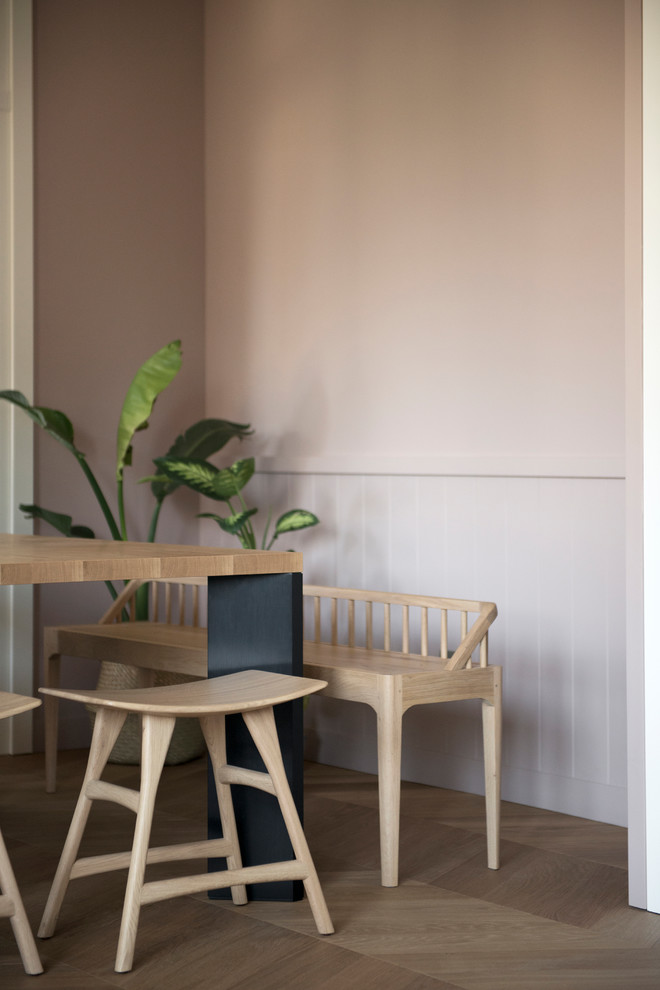 Réalisation d'une grande salle à manger ouverte sur la cuisine design avec un mur rose, parquet clair et un sol marron.