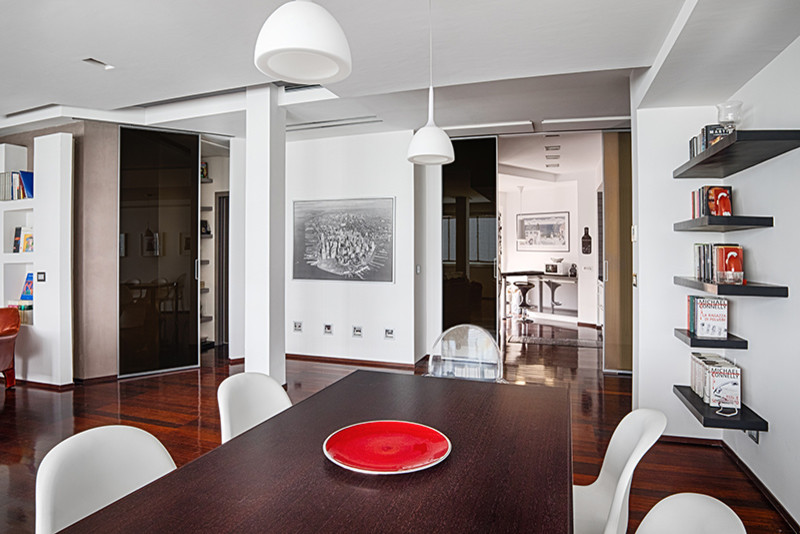 Immagine di una sala da pranzo aperta verso il soggiorno design di medie dimensioni con pareti bianche, parquet scuro e pavimento marrone