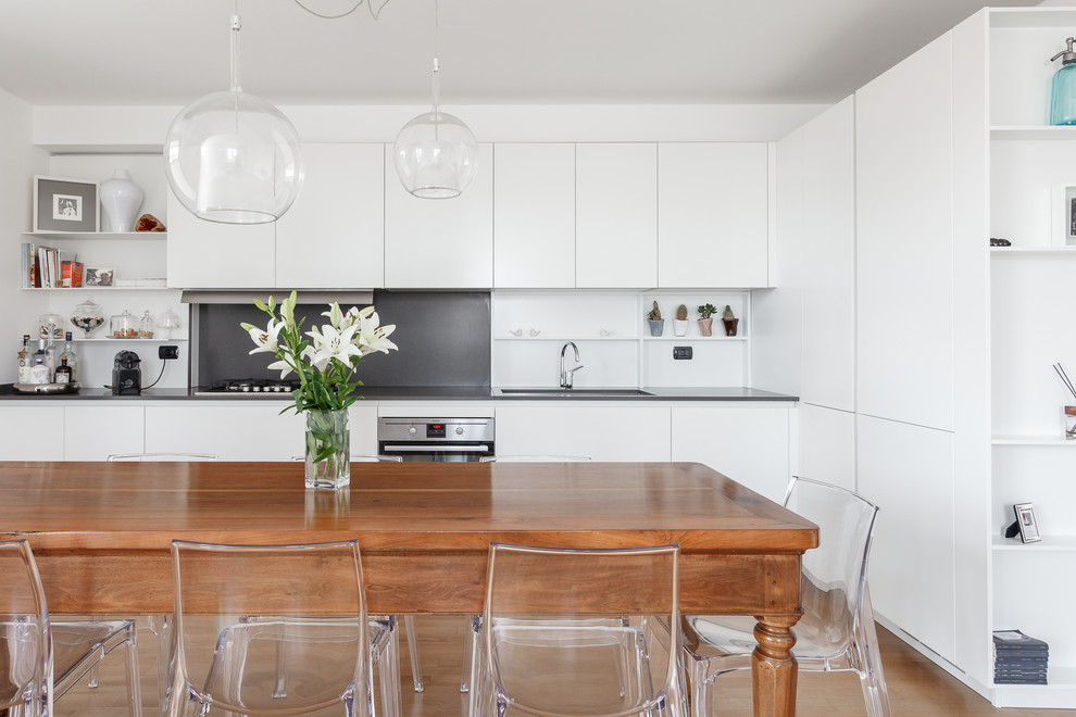 Idee per una sala da pranzo aperta verso la cucina contemporanea con pareti bianche, pavimento in legno massello medio e pavimento marrone