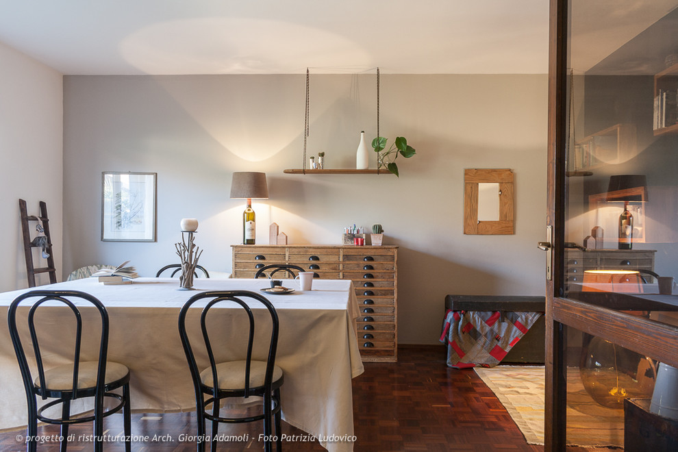 Idee per una sala da pranzo aperta verso il soggiorno boho chic con pareti grigie e pavimento in legno massello medio