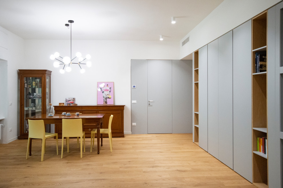 Idee per una grande sala da pranzo aperta verso il soggiorno minimal con pareti bianche, parquet chiaro e pareti in legno