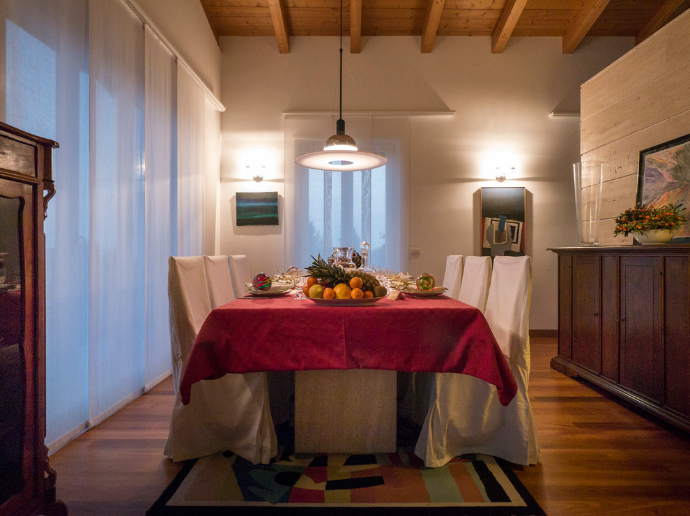 Aménagement d'une salle à manger ouverte sur le salon éclectique de taille moyenne avec un mur blanc, un sol en bois brun et aucune cheminée.