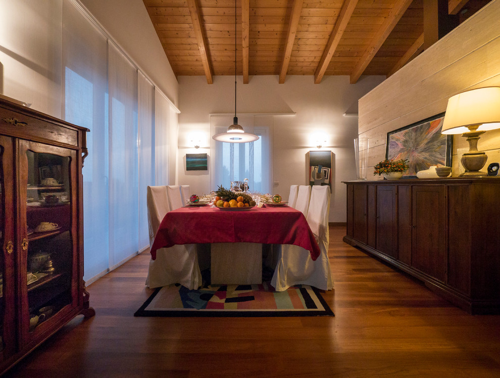 Réalisation d'une salle à manger ouverte sur le salon bohème de taille moyenne avec un mur blanc, un sol en bois brun et aucune cheminée.