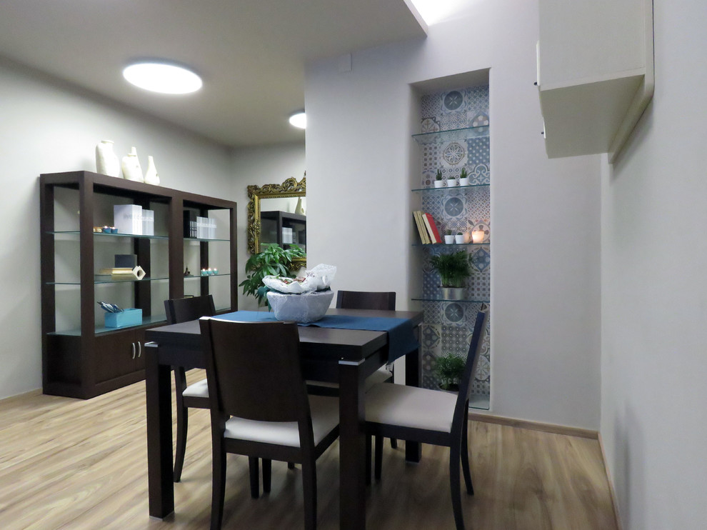 Cette photo montre une petite salle à manger ouverte sur le salon éclectique avec un mur marron, sol en stratifié et un sol marron.
