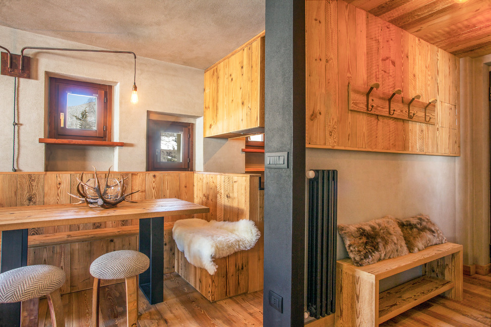 Idée de décoration pour une salle à manger ouverte sur la cuisine chalet avec un sol en bois brun, un mur beige et un sol marron.