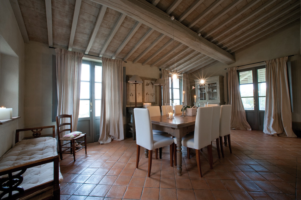 Foto di una sala da pranzo country chiusa e di medie dimensioni con pareti beige e pavimento in mattoni