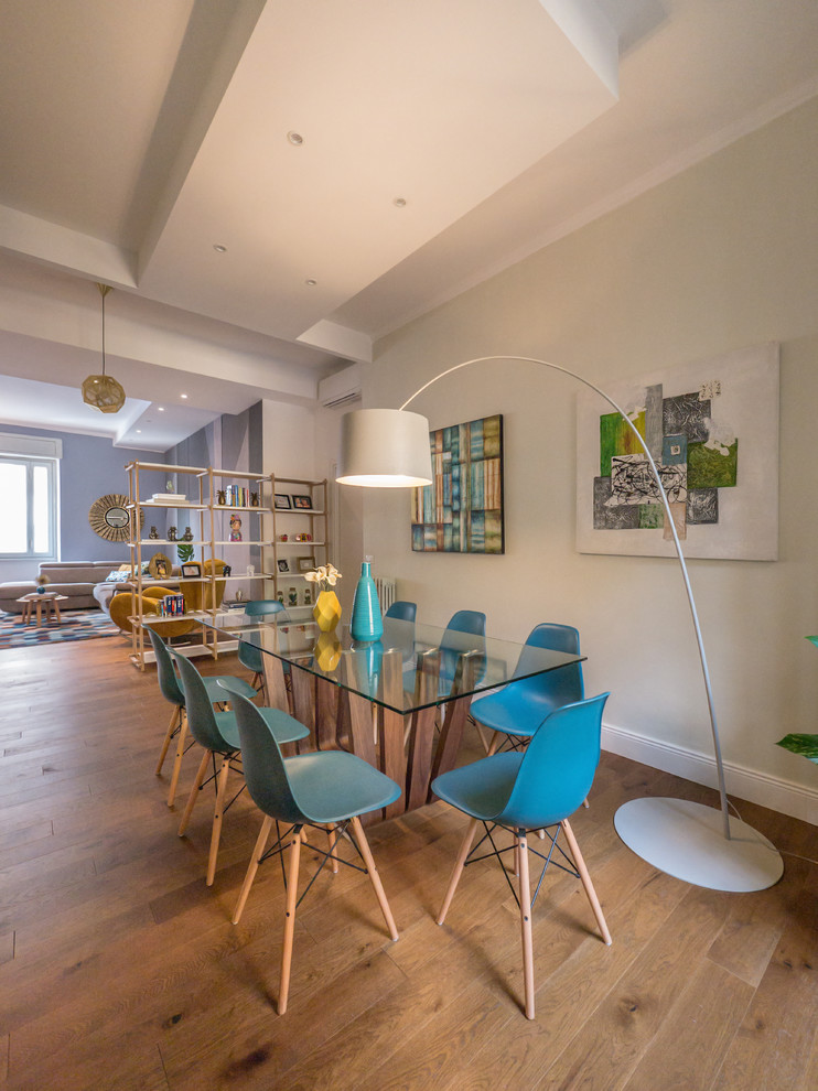 Esempio di una sala da pranzo aperta verso il soggiorno design di medie dimensioni con pareti grigie, pavimento in legno massello medio e nessun camino