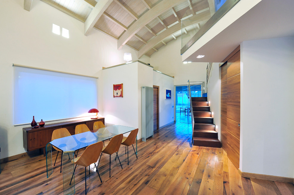 Immagine di una sala da pranzo contemporanea con pareti bianche e pavimento in legno massello medio