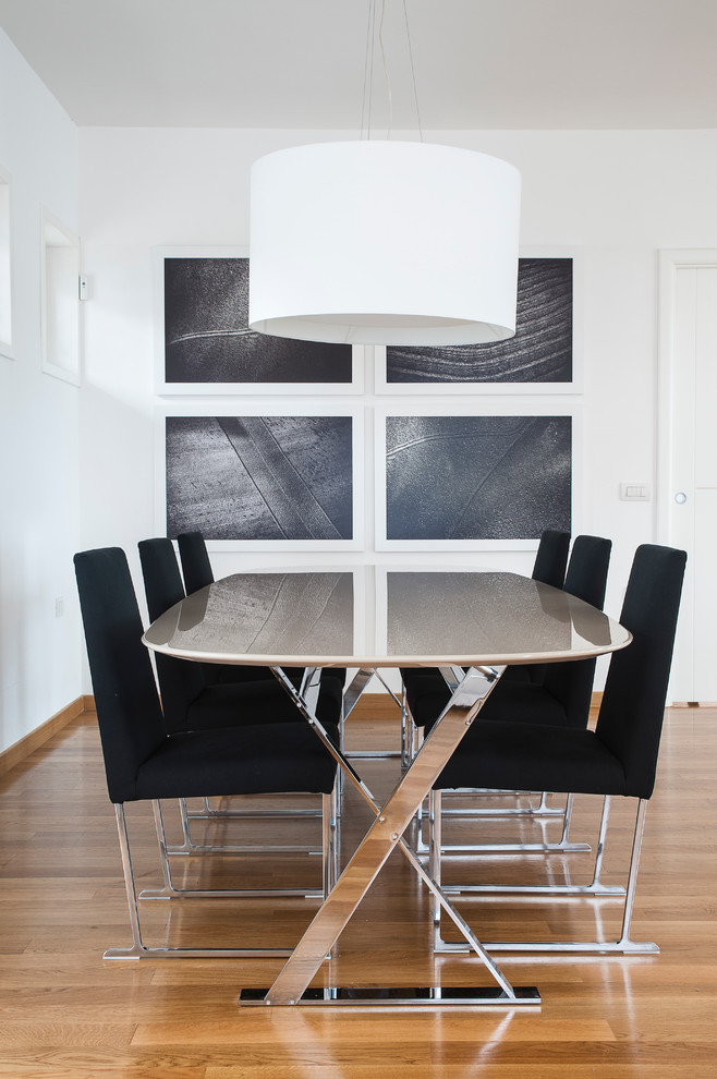 На фото: столовая в современном стиле с белыми стенами и светлым паркетным полом