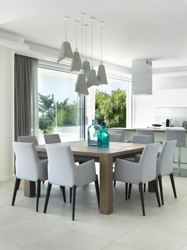 Immagine di una sala da pranzo aperta verso la cucina minimal di medie dimensioni con pareti bianche, pavimento in gres porcellanato e pavimento bianco