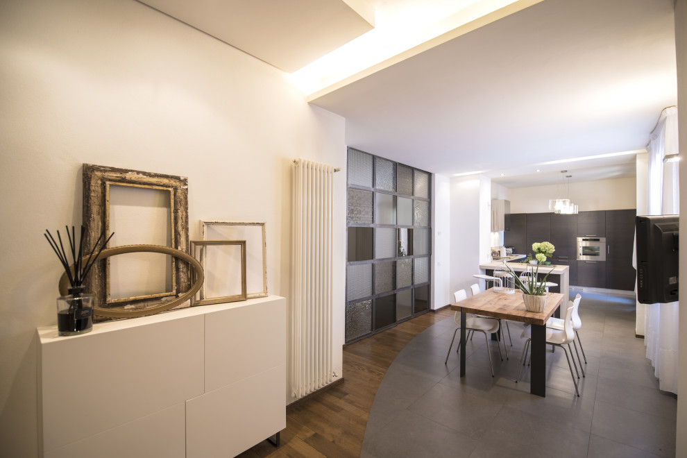 Mid-sized urban light wood floor, brown floor, tray ceiling and wood wall great room photo in Florence with white walls