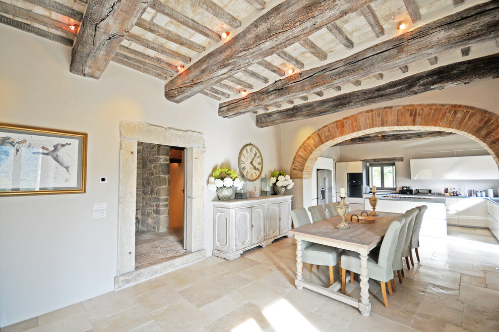 Esempio di un'ampia sala da pranzo aperta verso il soggiorno country con pavimento in pietra calcarea, pavimento beige e pareti bianche