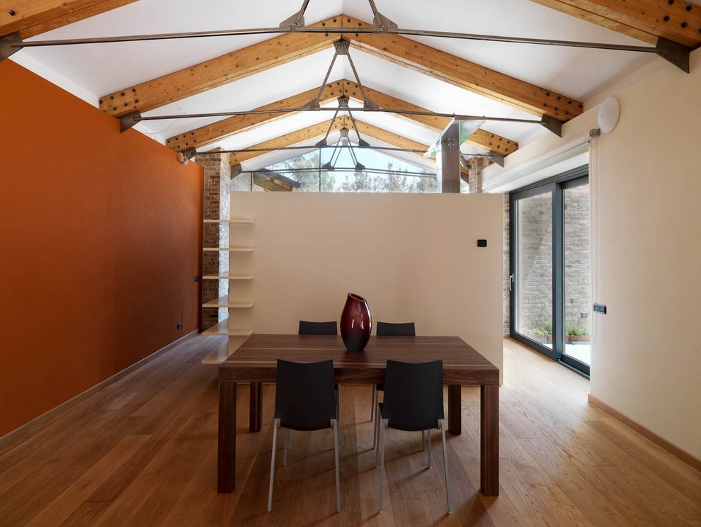 Example of a huge trendy medium tone wood floor great room design in Turin with orange walls