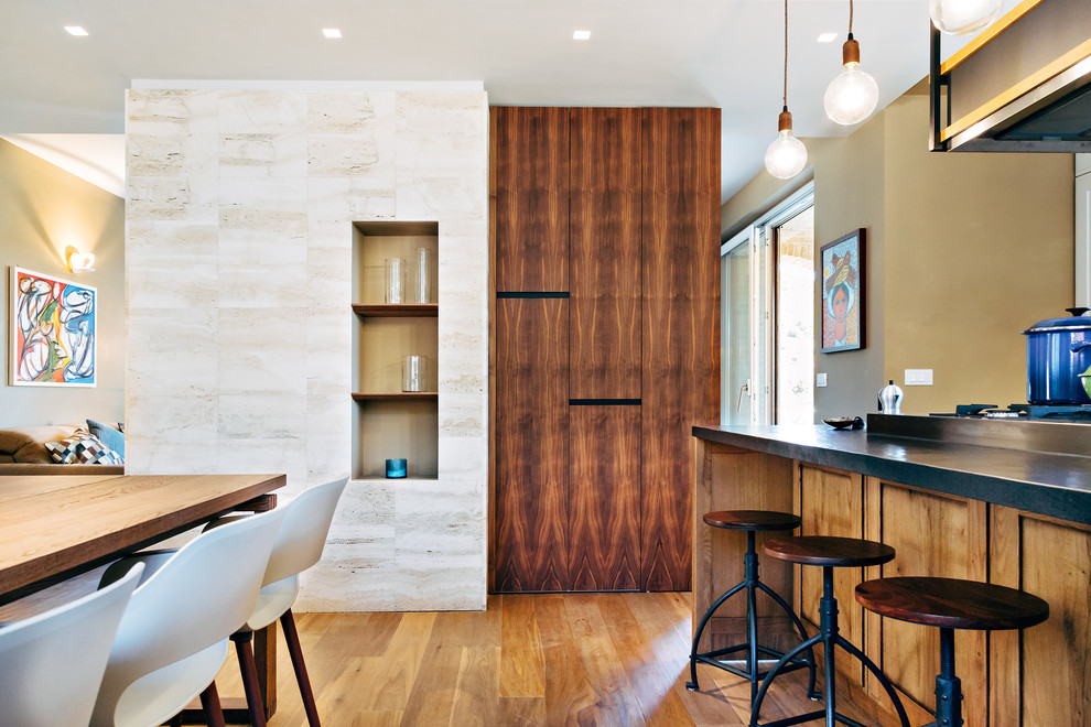 Idee per una sala da pranzo aperta verso la cucina contemporanea di medie dimensioni con pareti beige, parquet scuro e cornice del camino in pietra