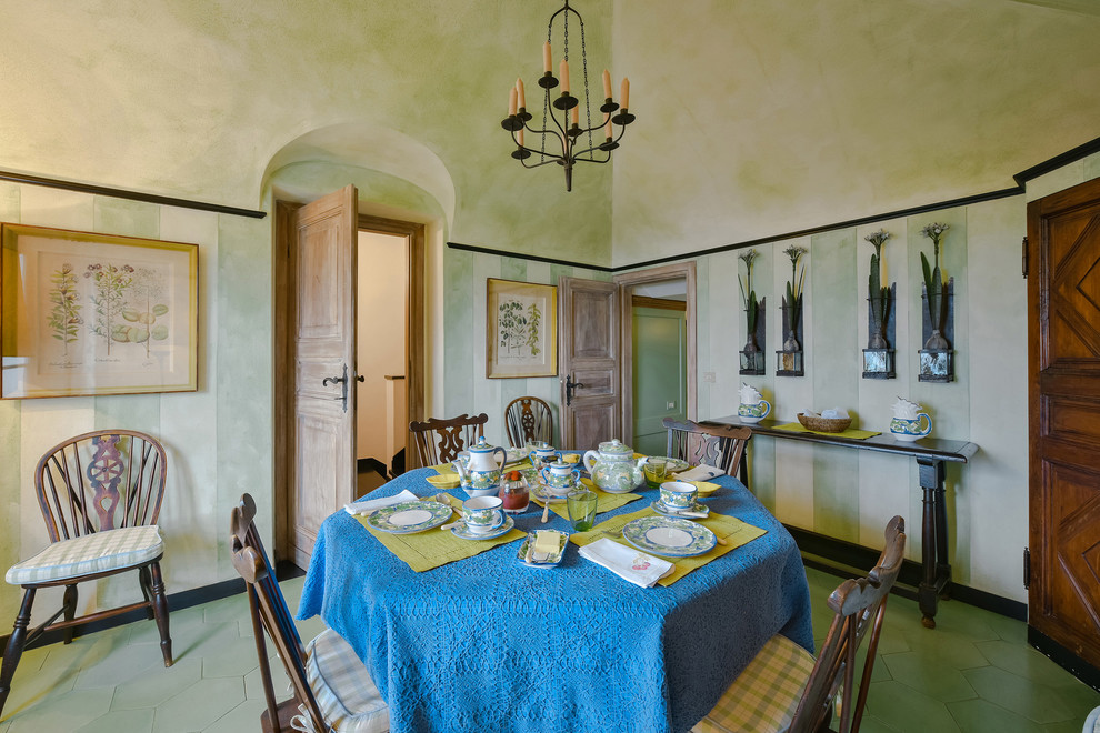На фото: отдельная столовая в средиземноморском стиле с зелеными стенами и зеленым полом без камина с