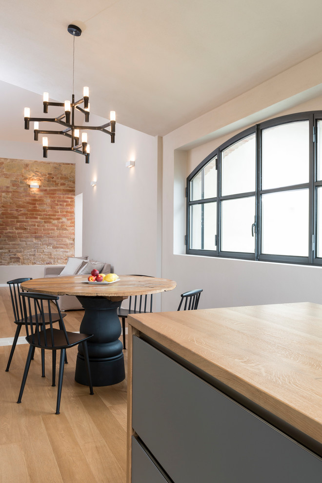 Immagine di una sala da pranzo aperta verso il soggiorno country di medie dimensioni con parquet chiaro, pareti bianche e pavimento beige