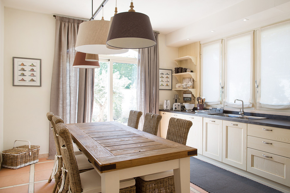 Inspiration pour une salle à manger ouverte sur la cuisine rustique de taille moyenne avec un mur blanc, tomettes au sol et un sol orange.