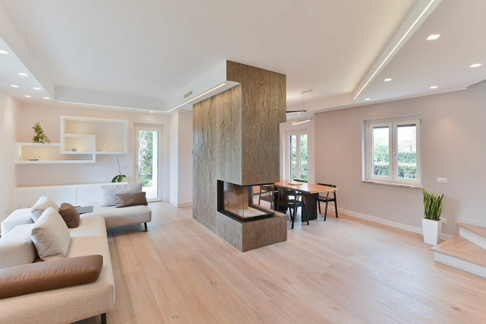 Idée de décoration pour une salle à manger minimaliste avec un mur gris, un sol en carrelage de porcelaine et un manteau de cheminée en pierre.