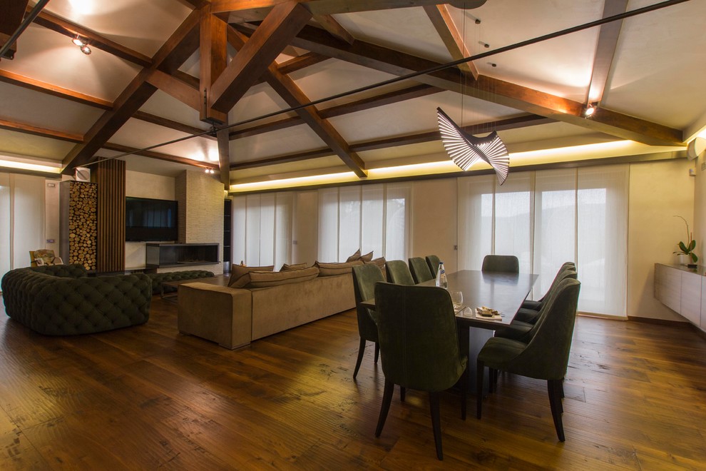 Cette image montre une très grande salle à manger ouverte sur le salon design avec un sol en bois brun et un mur blanc.