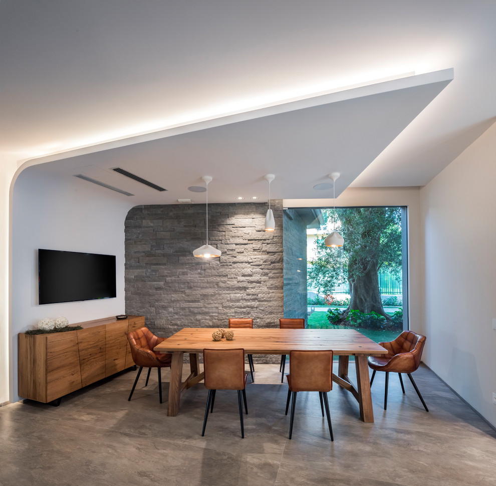 Aménagement d'une salle à manger contemporaine fermée avec un mur blanc et un sol gris.