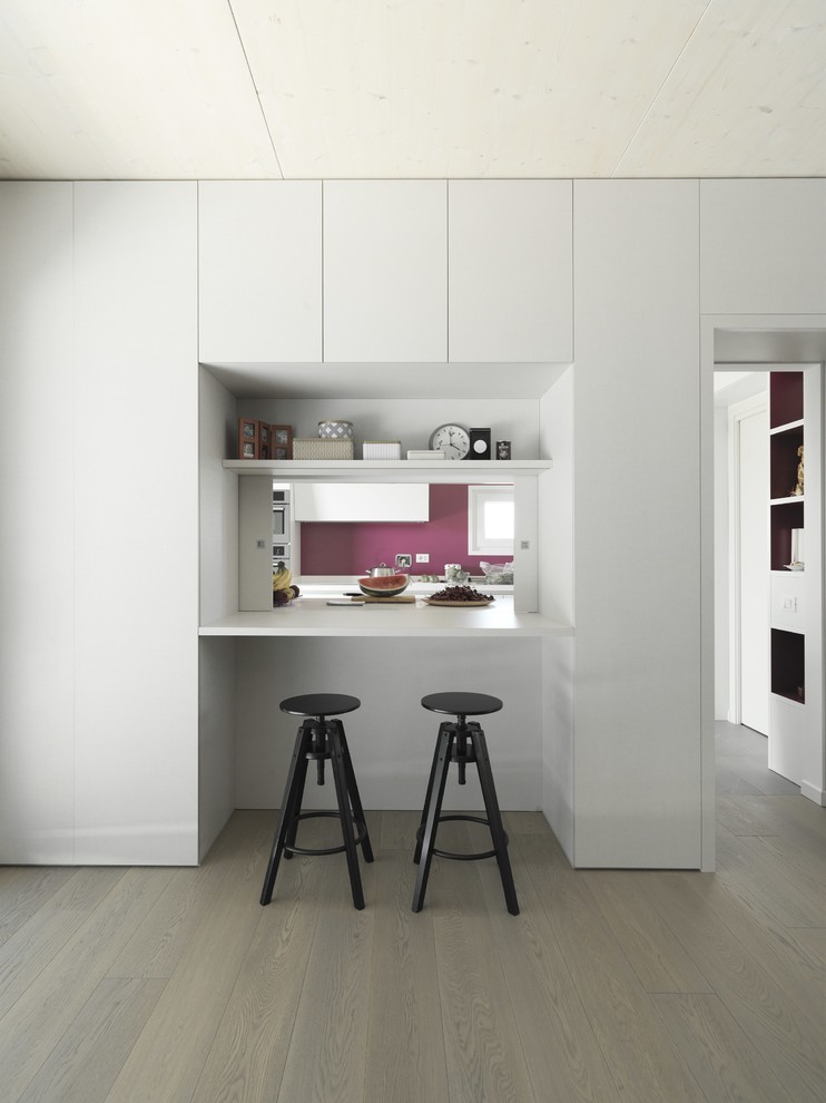 Immagine di una piccola sala da pranzo aperta verso il soggiorno minimal con pareti bianche e parquet chiaro