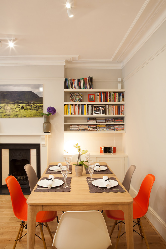 Idee per una sala da pranzo aperta verso il soggiorno classica con pareti grigie, parquet chiaro e camino classico