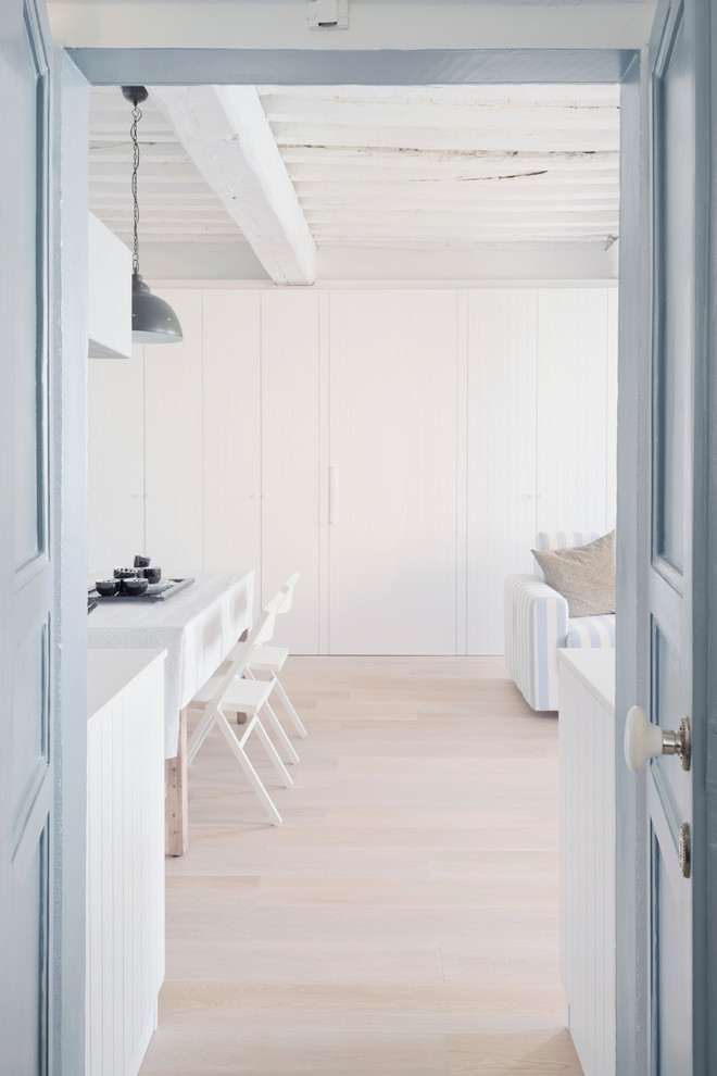 Esempio di una sala da pranzo aperta verso la cucina stile marino di medie dimensioni con pareti bianche e parquet chiaro