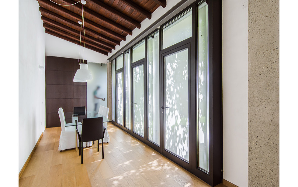 Esempio di una grande sala da pranzo minimal con pareti bianche, parquet chiaro, pavimento beige e travi a vista