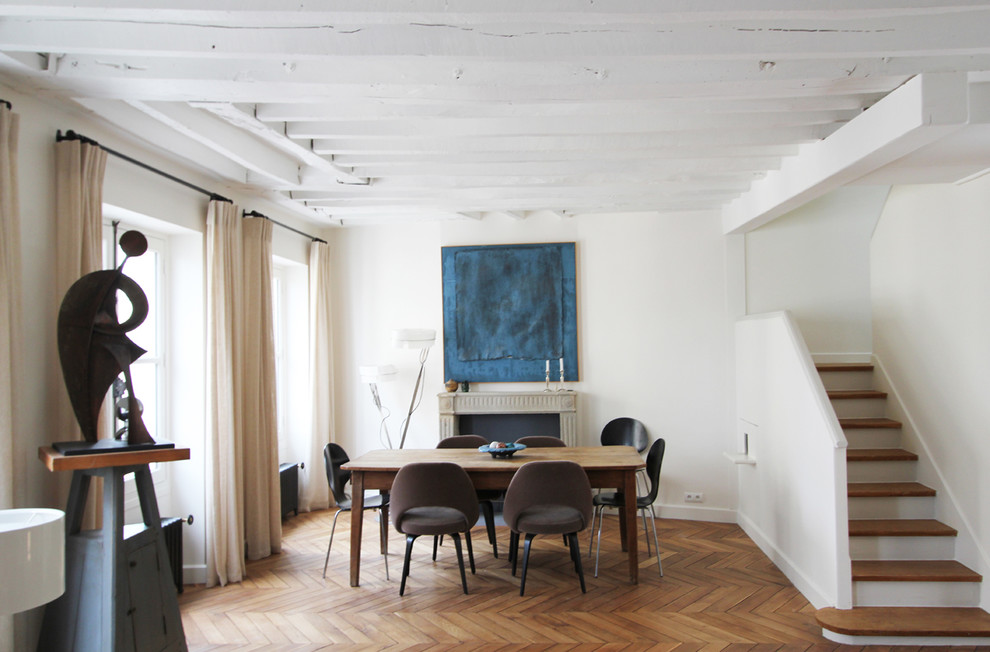 Photo of a contemporary dining room in Paris with white walls.