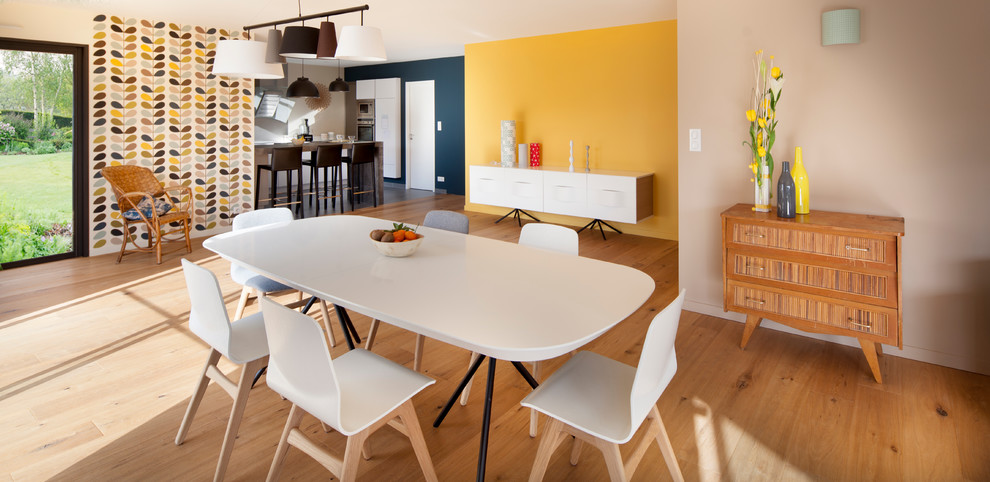 На фото: большая гостиная-столовая в современном стиле с светлым паркетным полом и желтыми стенами без камина с