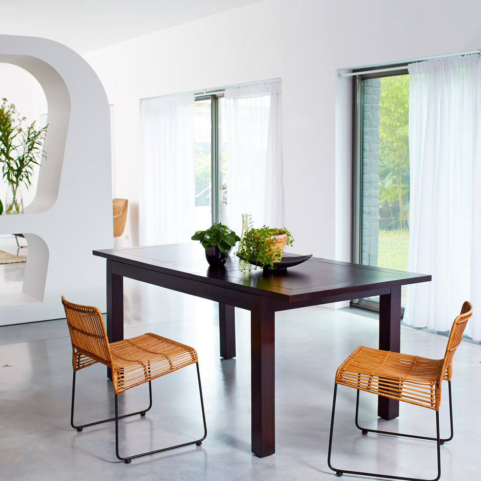 На фото: гостиная-столовая среднего размера в современном стиле с белыми стенами и бетонным полом с