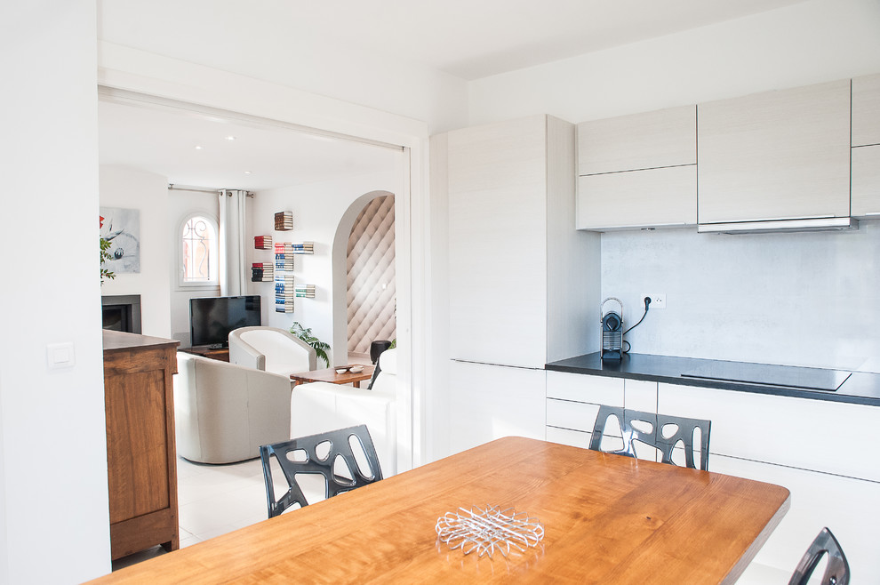 Immagine di una sala da pranzo aperta verso la cucina minimal di medie dimensioni con pareti bianche