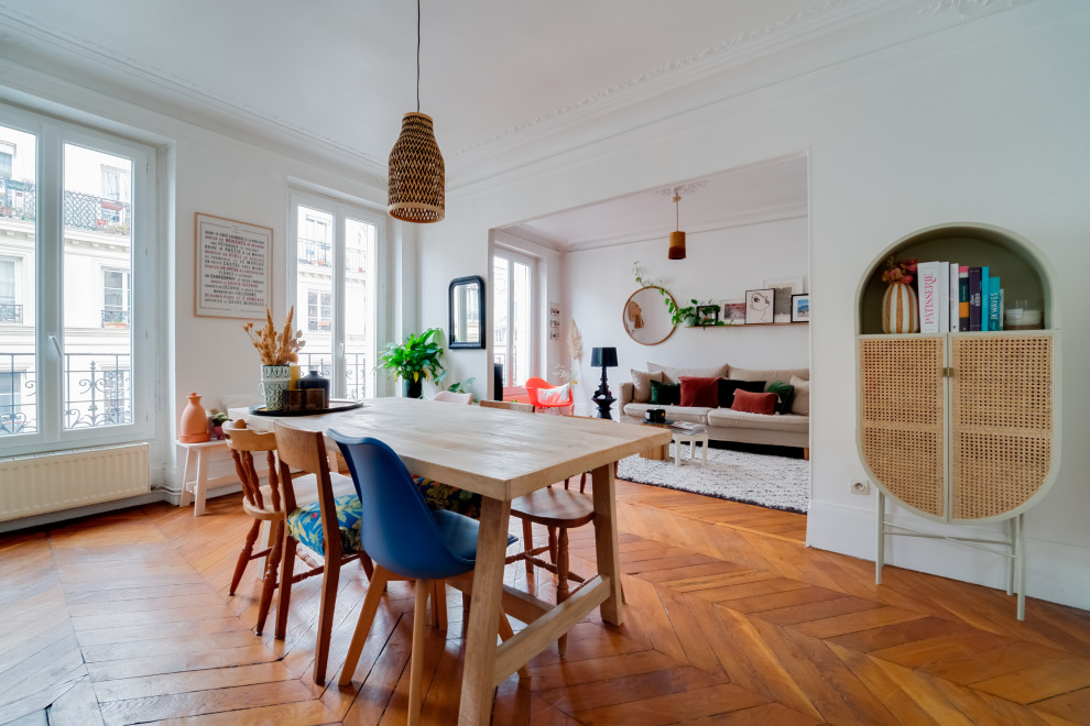 Design ideas for a medium sized bohemian dining room in Paris with dark hardwood flooring, white walls and brown floors.