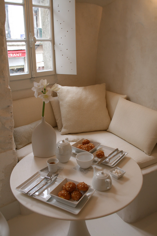 Cette photo montre une petite salle à manger romantique avec une banquette d'angle, un mur blanc, parquet clair et un sol blanc.