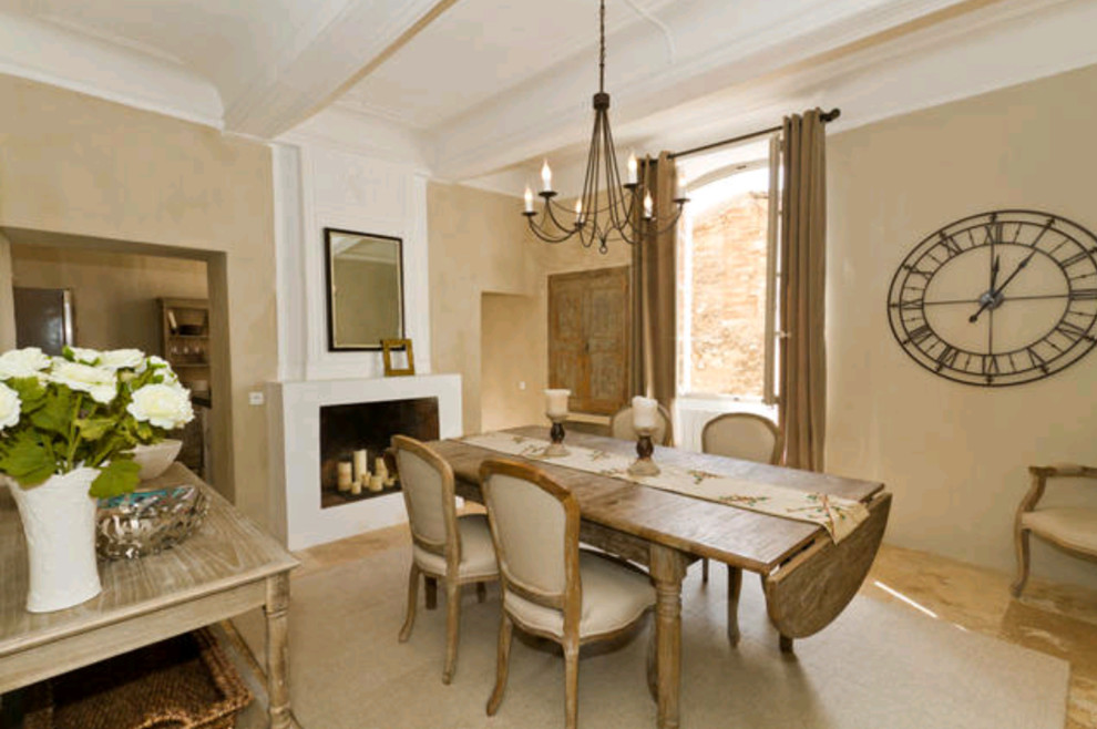 Design ideas for a large farmhouse enclosed dining room in Marseille with beige walls, travertine flooring, a standard fireplace and a plastered fireplace surround.