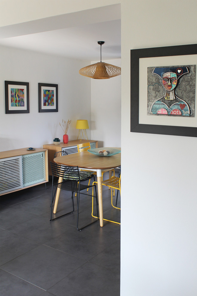Immagine di una sala da pranzo aperta verso il soggiorno design di medie dimensioni con pareti bianche, pavimento con piastrelle in ceramica, stufa a legna e pavimento grigio