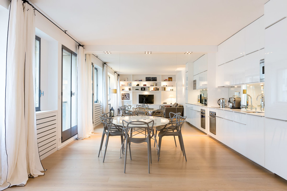 Imagen de comedor de cocina contemporáneo grande con paredes blancas y suelo de madera clara