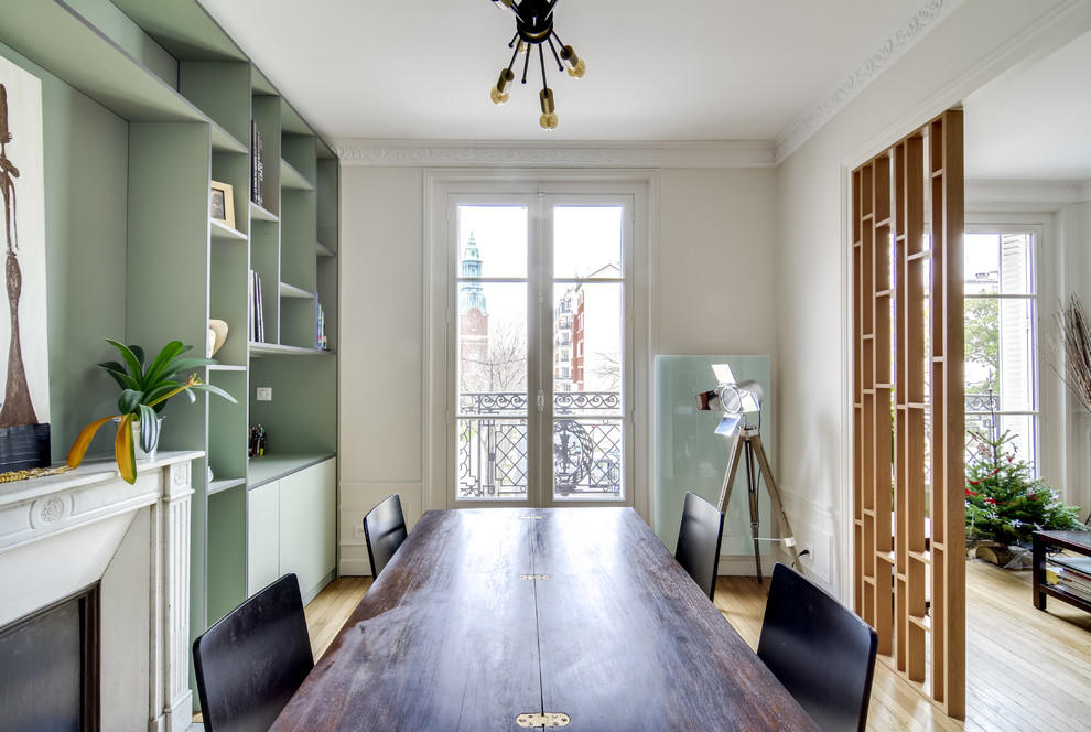 Mittelgroßes Modernes Esszimmer mit grauer Wandfarbe, hellem Holzboden, Kamin, verputzter Kaminumrandung und beigem Boden in Paris
