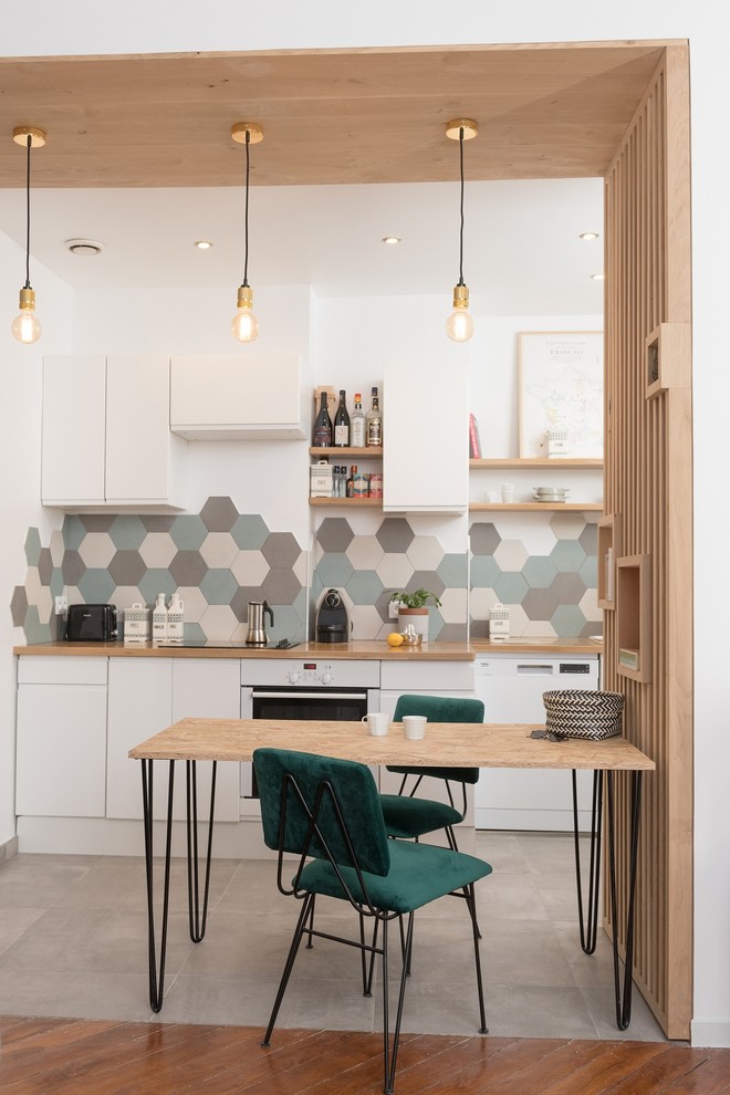 Cette photo montre une salle à manger ouverte sur la cuisine tendance avec un mur blanc et un sol multicolore.