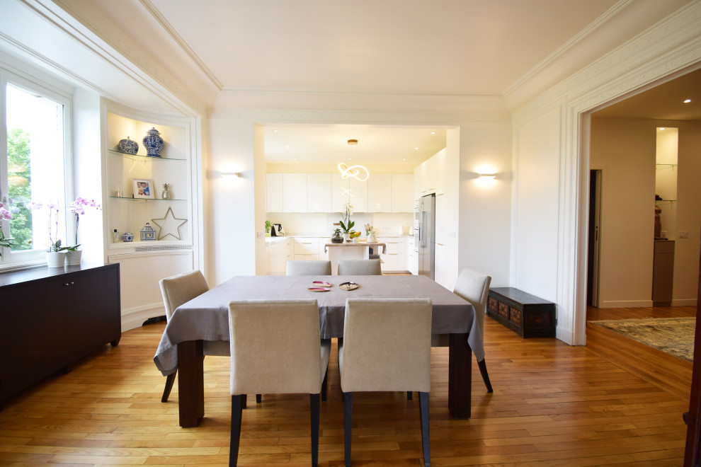 Cette photo montre une grande salle à manger ouverte sur le salon tendance avec parquet clair, un sol beige et boiseries.