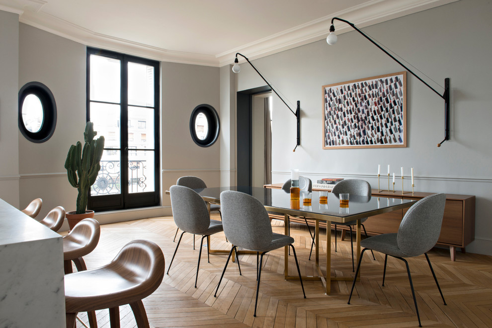 Idées déco pour une salle à manger ouverte sur la cuisine contemporaine avec un mur gris, un sol en bois brun, un sol marron et éclairage.