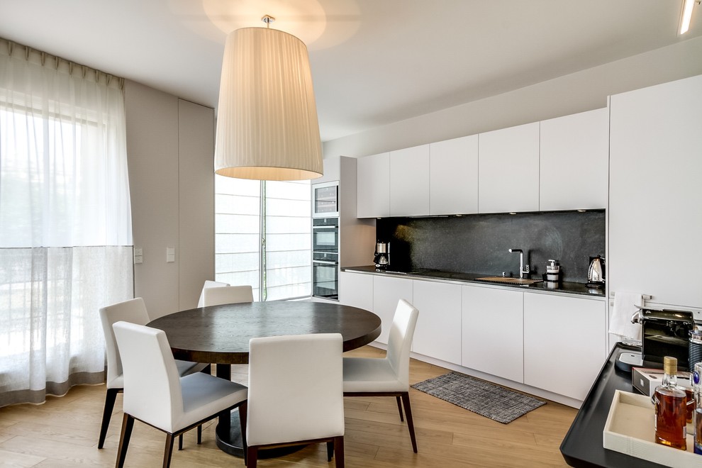 Cette image montre une salle à manger ouverte sur la cuisine design de taille moyenne avec un mur beige.