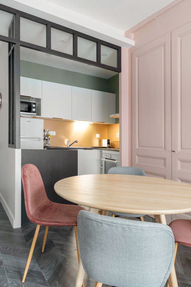 Idee per una piccola sala da pranzo aperta verso il soggiorno design con pareti rosa, pavimento in laminato e pavimento grigio