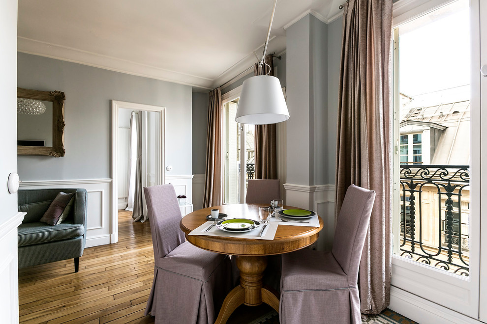 Offenes, Kleines Modernes Esszimmer mit blauer Wandfarbe und braunem Holzboden in Paris