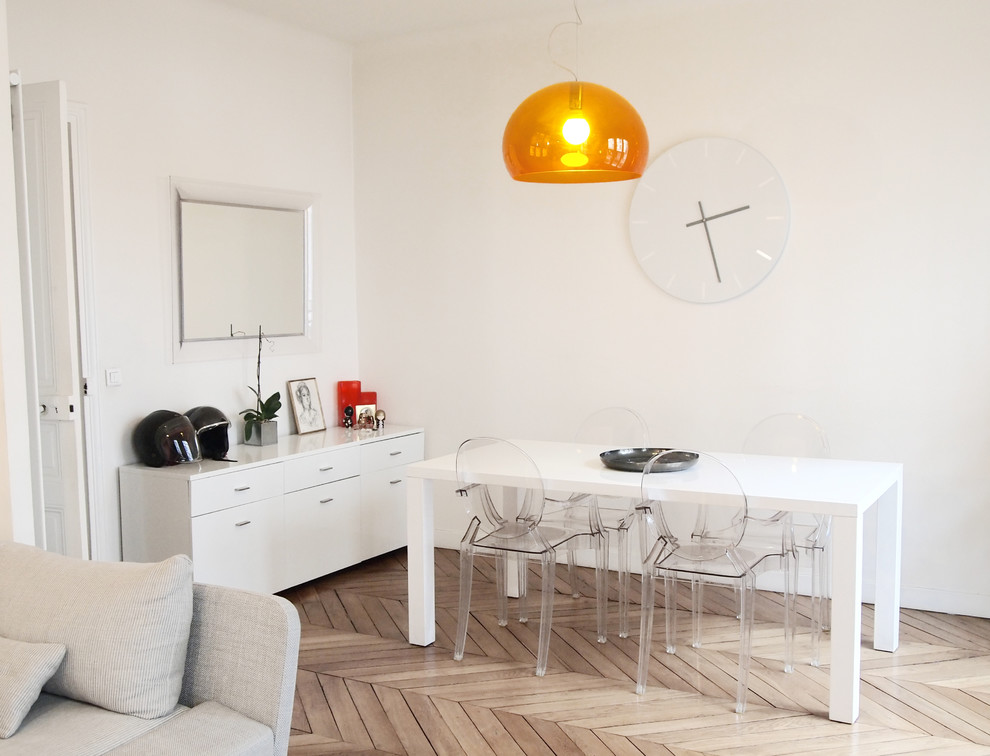 Example of a mid-sized trendy light wood floor great room design in Paris with white walls and no fireplace