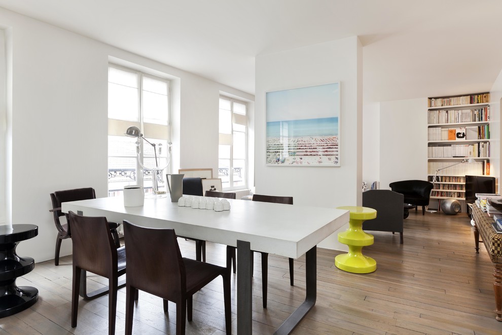 Photo of a contemporary open plan dining room in Paris with white walls and light hardwood flooring.