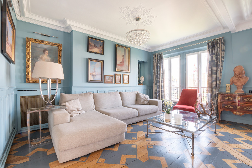 Großes Klassisches Esszimmer mit blauer Wandfarbe, gebeiztem Holzboden, buntem Boden und vertäfelten Wänden in Paris