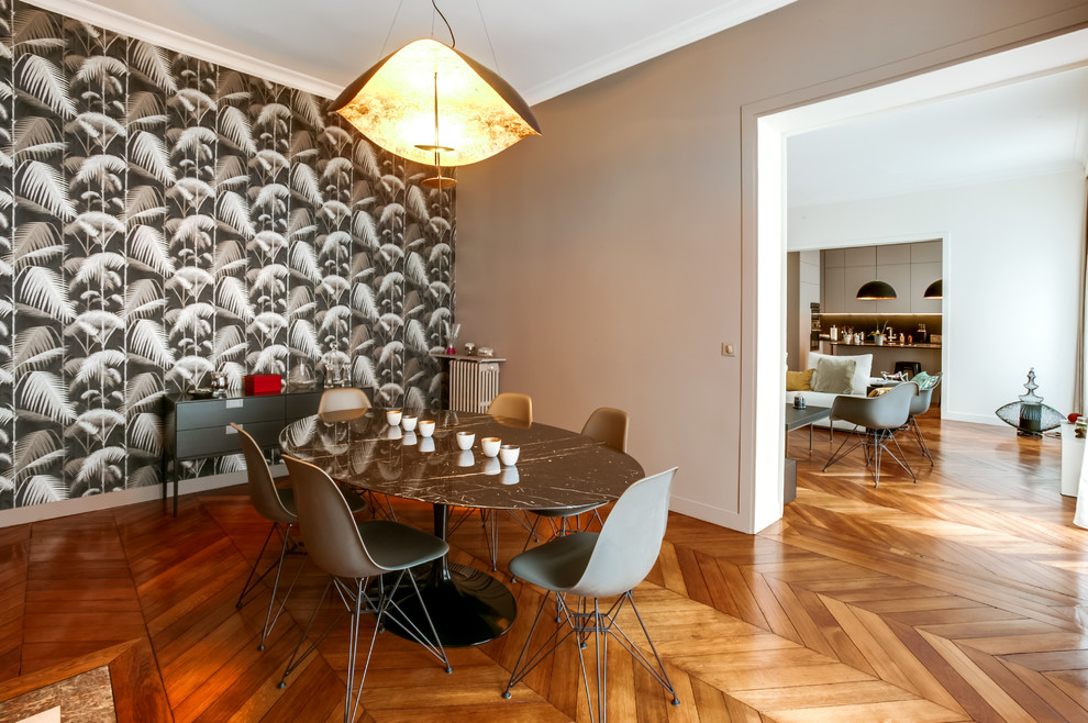 Idée de décoration pour une grande salle à manger ouverte sur le salon minimaliste avec un mur noir, un sol en bois brun et un sol marron.