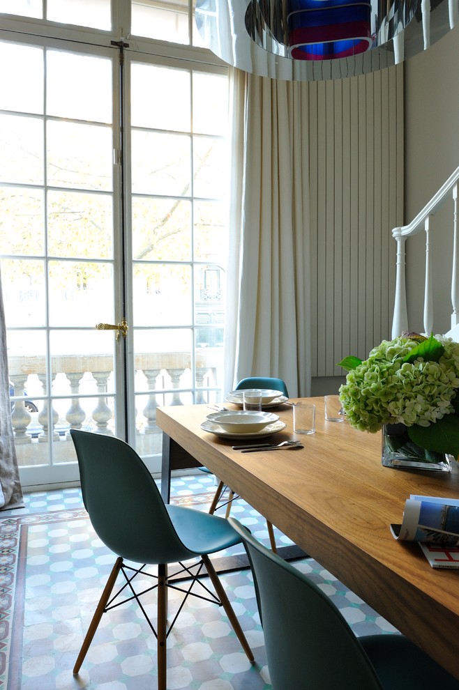 Medium sized bohemian dining room in Paris with white walls, light hardwood flooring and beige floors.